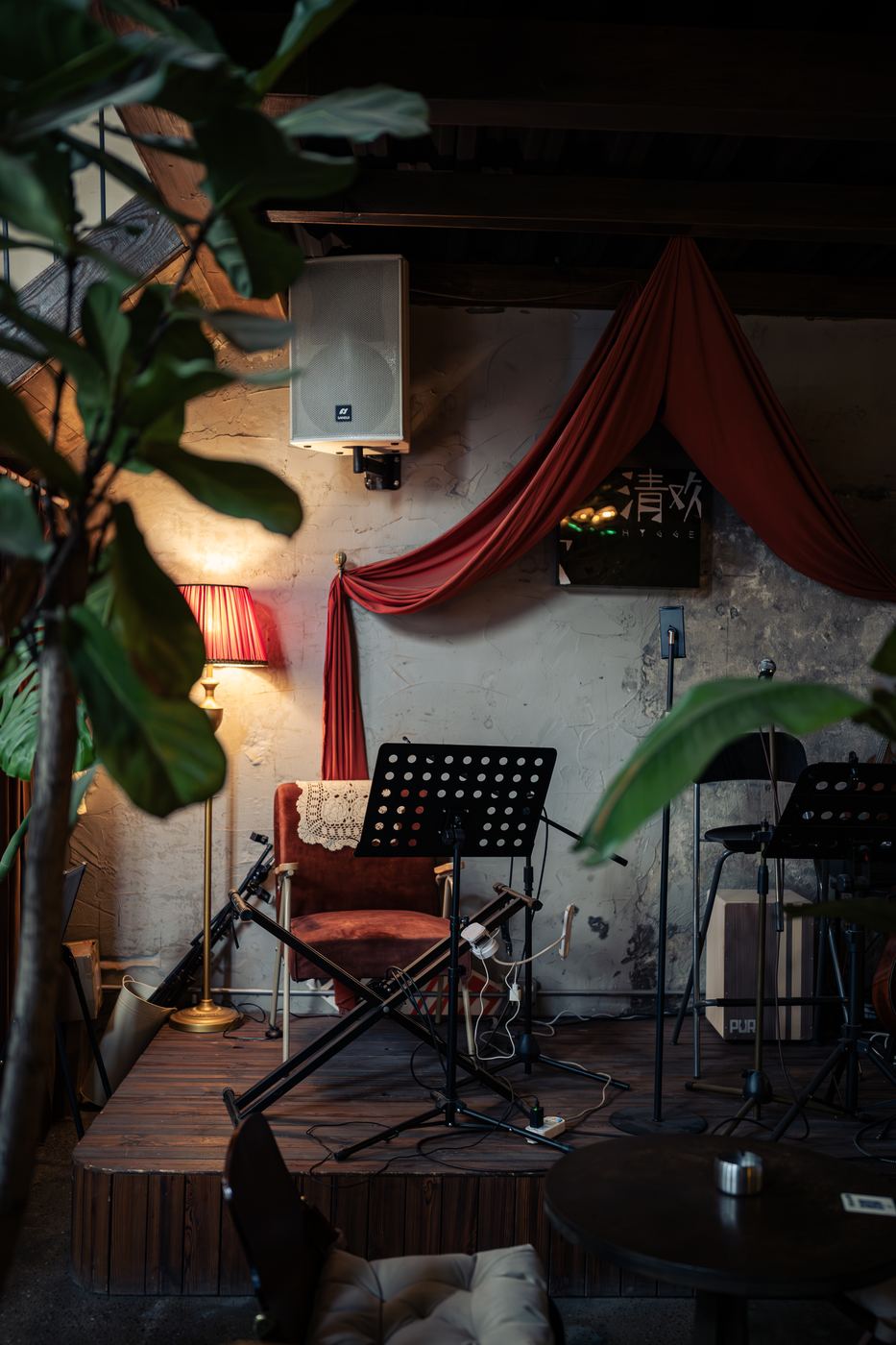 Cafe corner with red drapes, plants, and music stands