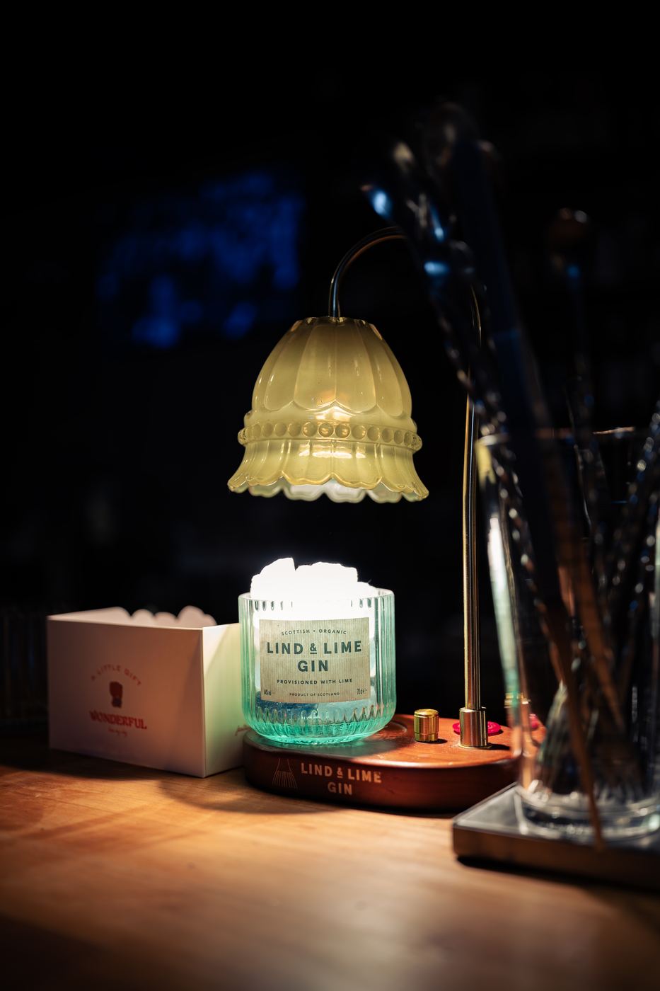 Candle-warmer lamp glowing in a dark bar