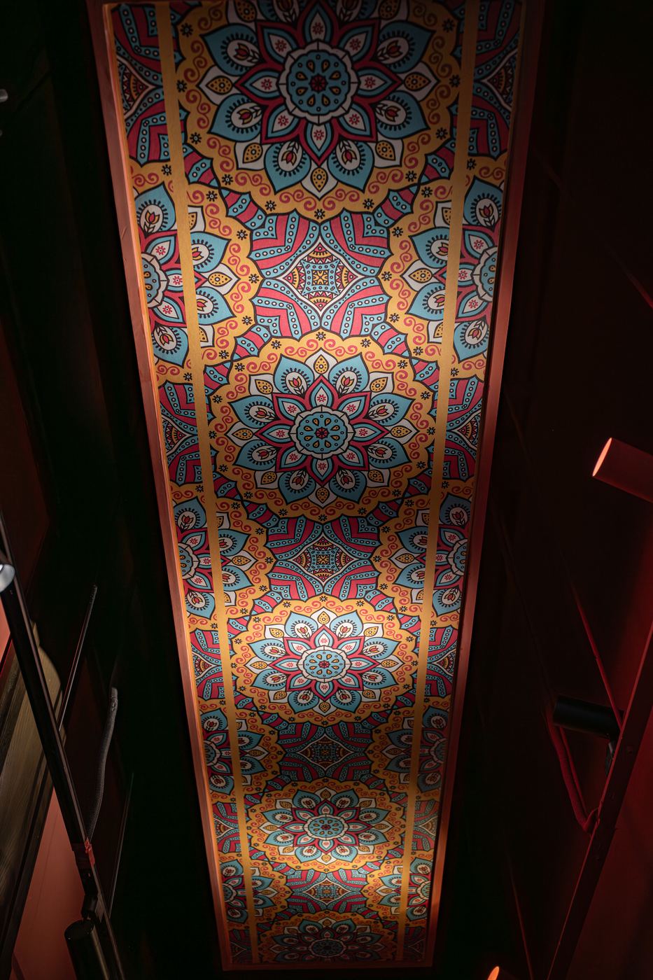 Ornate painted ceiling photographed in dim interior light