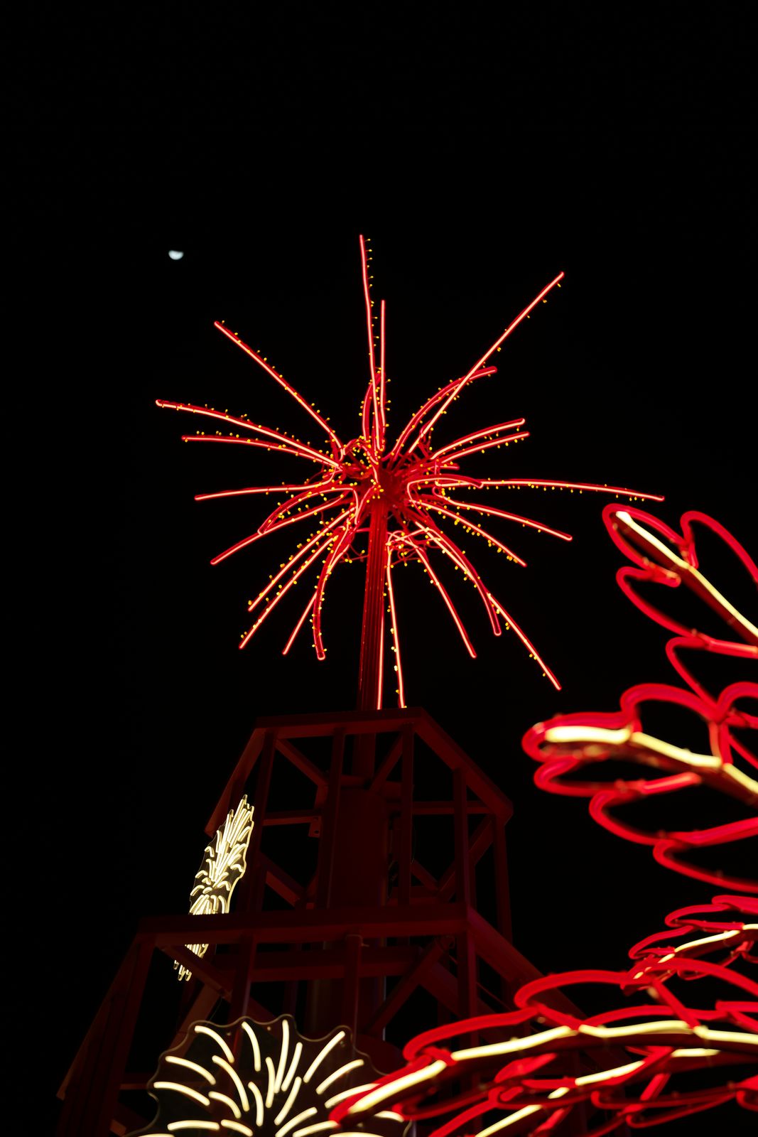 Red neon light installation glowing against the night sky